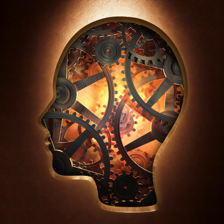 dark background with a glowing illustrated head outline. The head is filled with cogs and gears to illustrate the psychology of marketing on our brains.